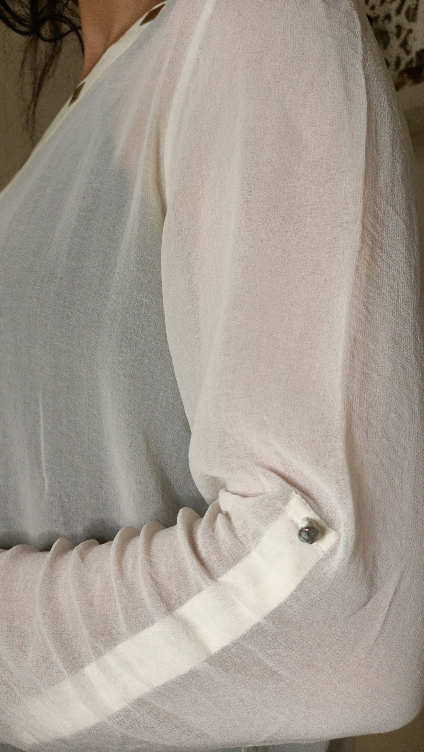 blouse fluide écrue aux détails dorés et ce pantalon vert émeraude créent un look à la fois élégant et décontracté.