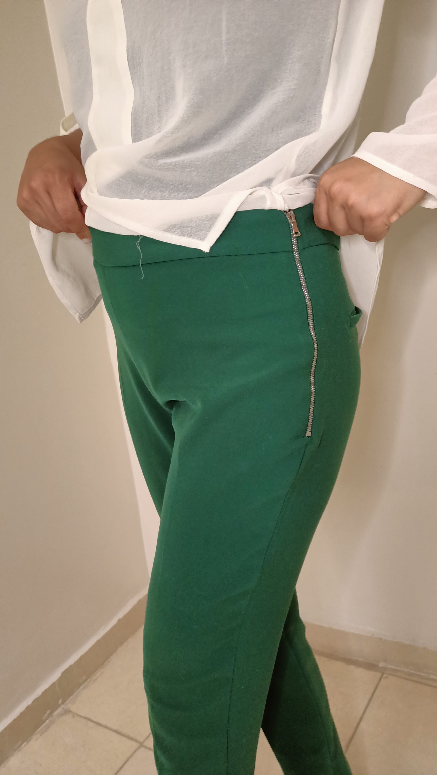 blouse fluide écrue aux détails dorés et ce pantalon vert émeraude créent un look à la fois élégant et décontracté.