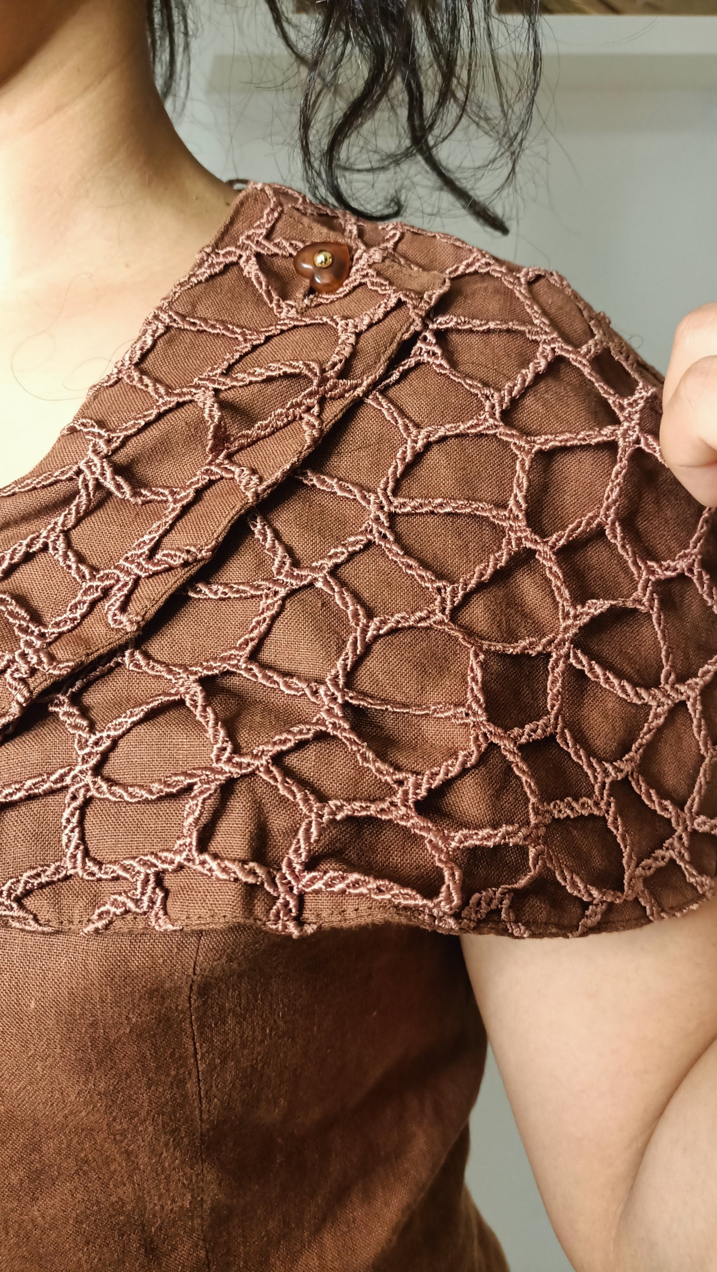 Ce haut vintage marron est une véritable pépite, avec son empiècement travaillé en macramé ou crochet qui lui donne un charme