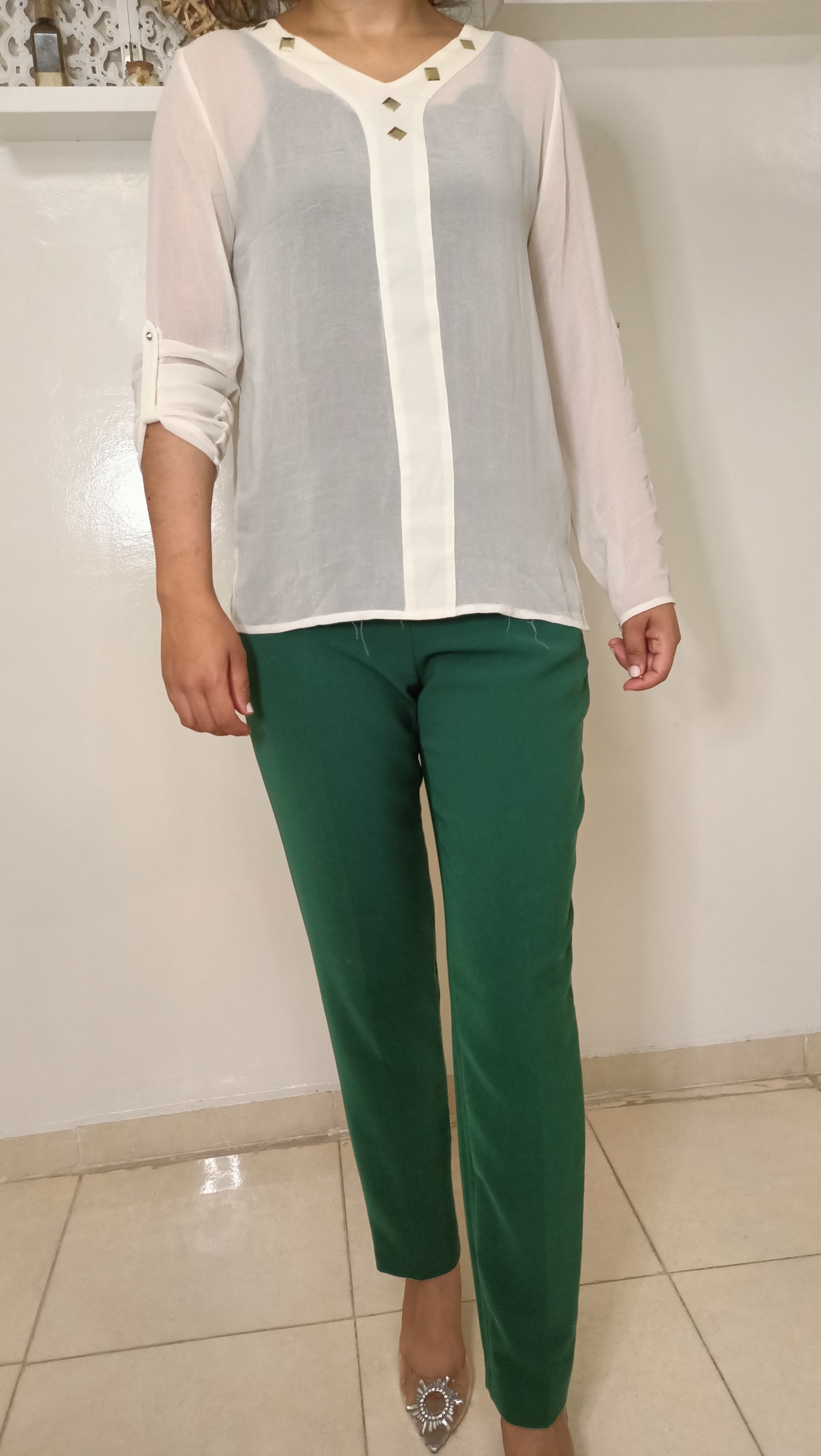 blouse fluide écrue aux détails dorés et ce pantalon vert émeraude créent un look à la fois élégant et décontracté.