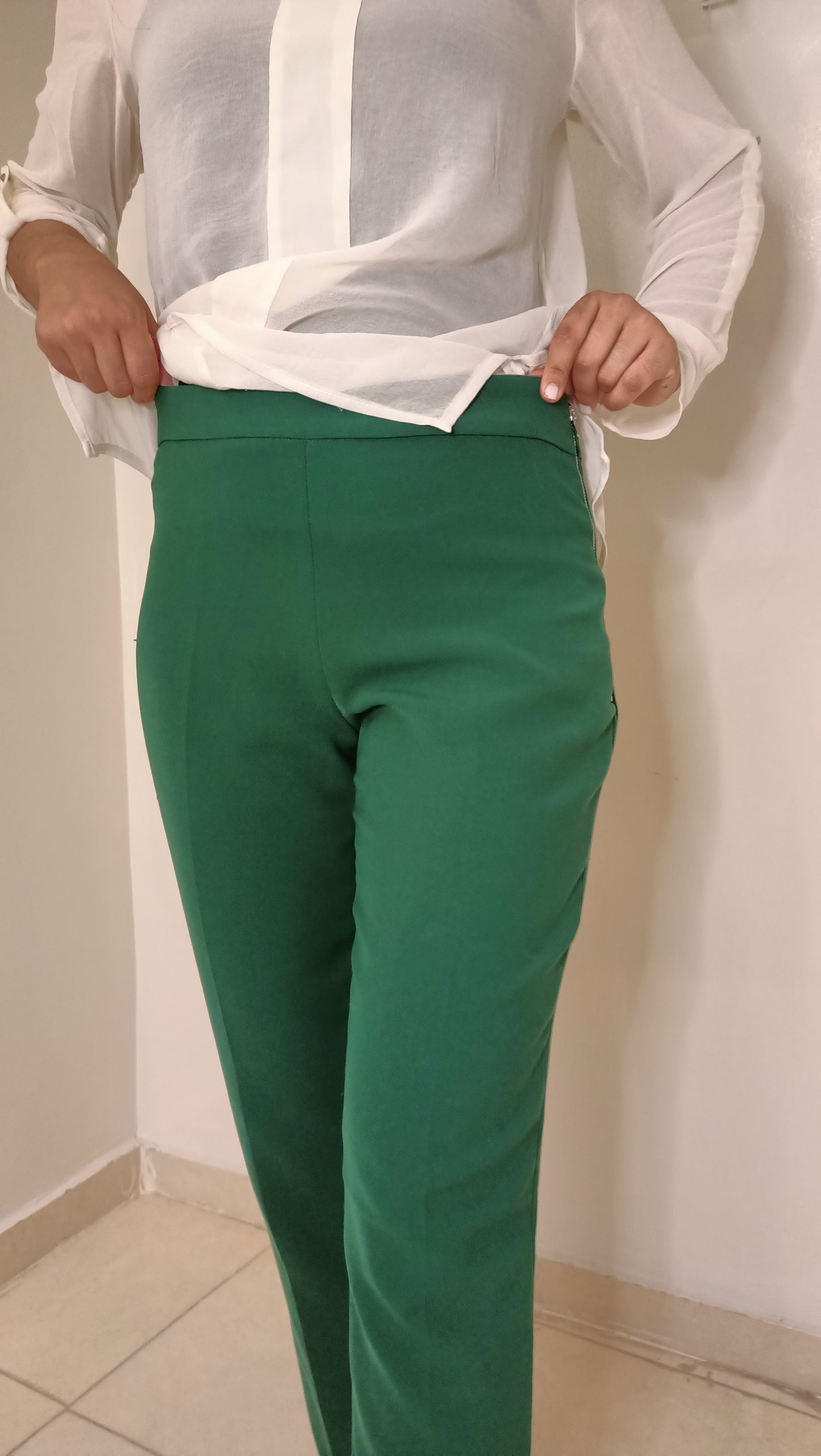 blouse fluide écrue aux détails dorés et ce pantalon vert émeraude créent un look à la fois élégant et décontracté.