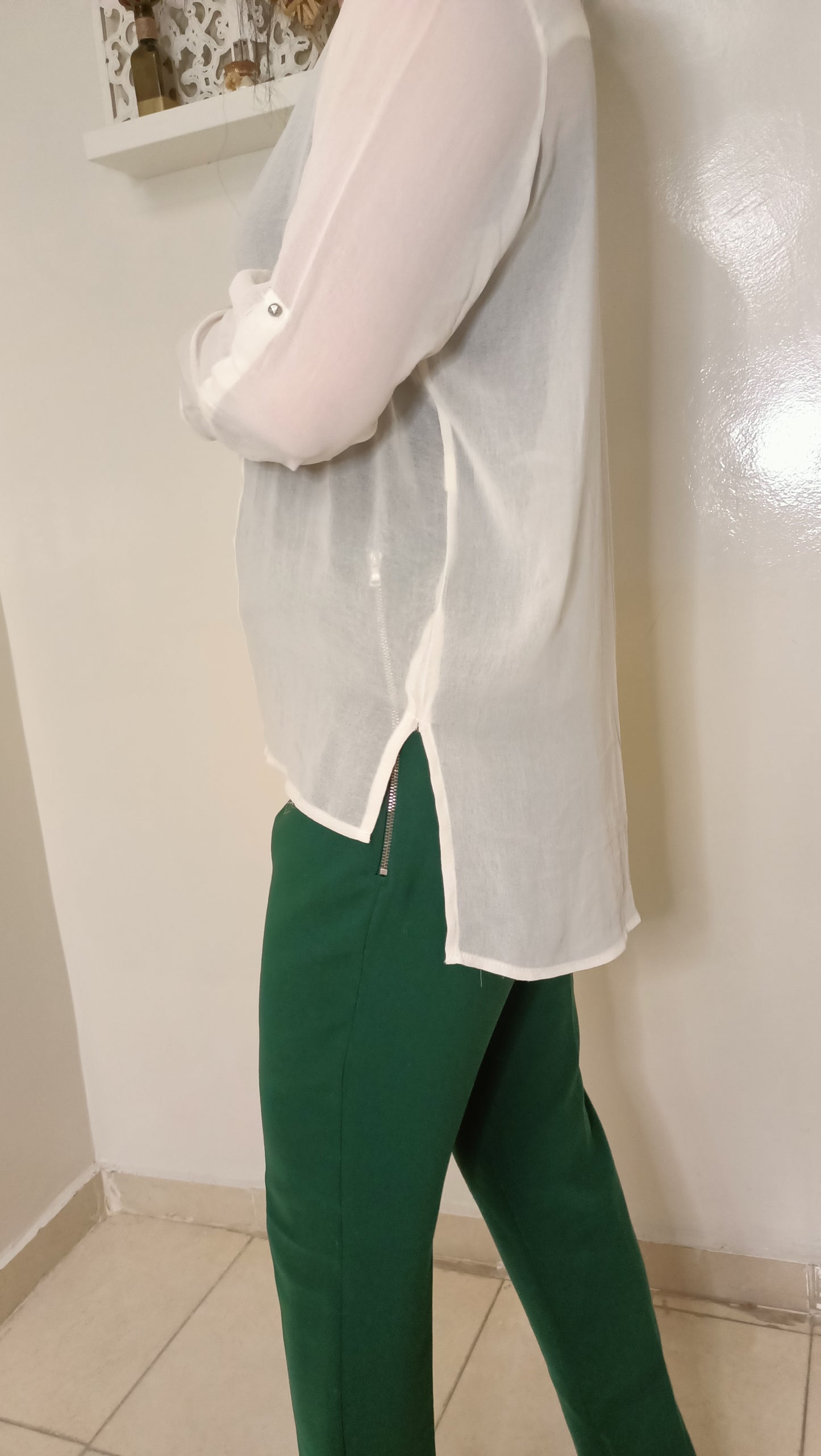 blouse fluide écrue aux détails dorés et ce pantalon vert émeraude créent un look à la fois élégant et décontracté.