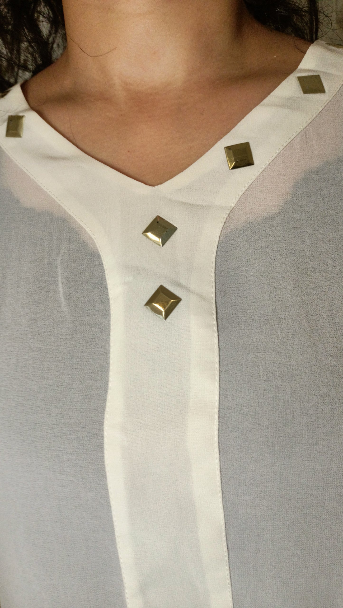 blouse fluide écrue aux détails dorés et ce pantalon vert émeraude créent un look à la fois élégant et décontracté.