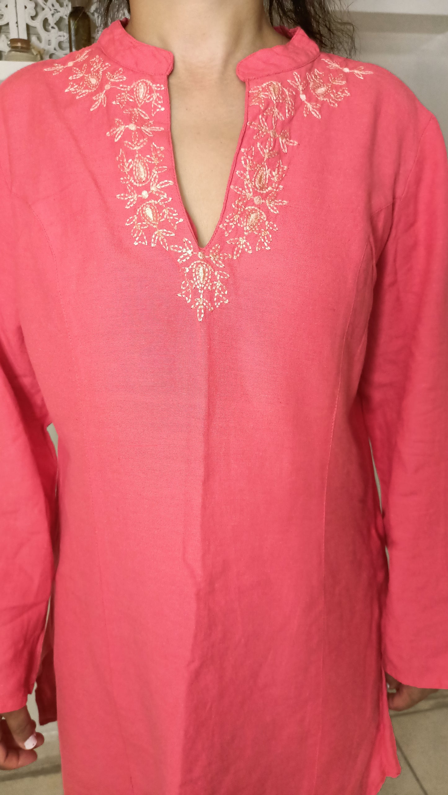 Craquez pour le charme délicat de cette sublime tunique vintage en lin rose. Ses broderies dorées et son col tunisien apportent une touche d'élégance