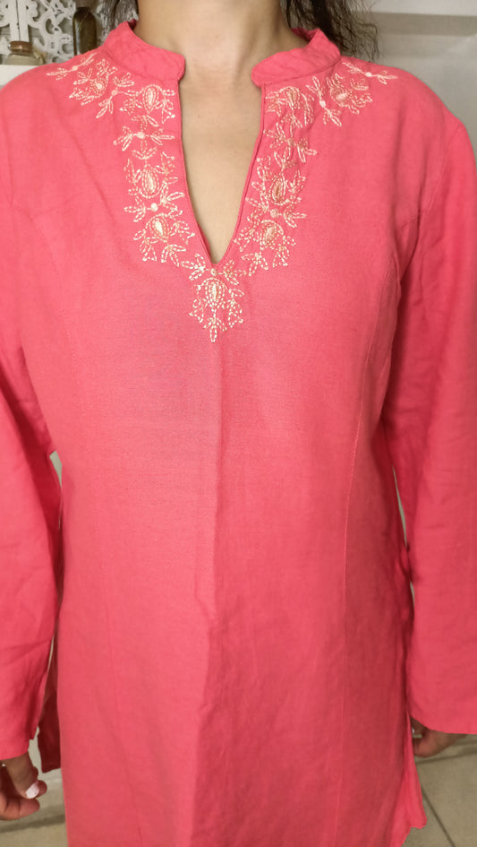 Craquez pour le charme délicat de cette sublime tunique vintage en lin rose. Ses broderies dorées et son col tunisien apportent une touche d'élégance