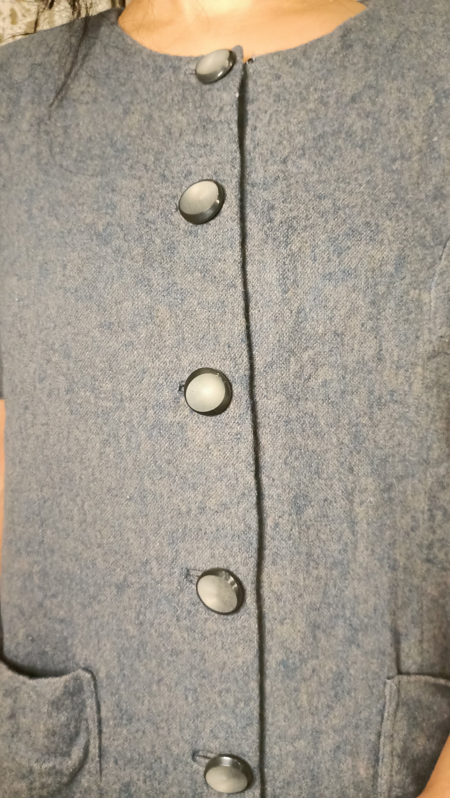manteau vintage gris chiné a un charme fou avec sa coupe droite, ses manches courtes et ses gros boutons.