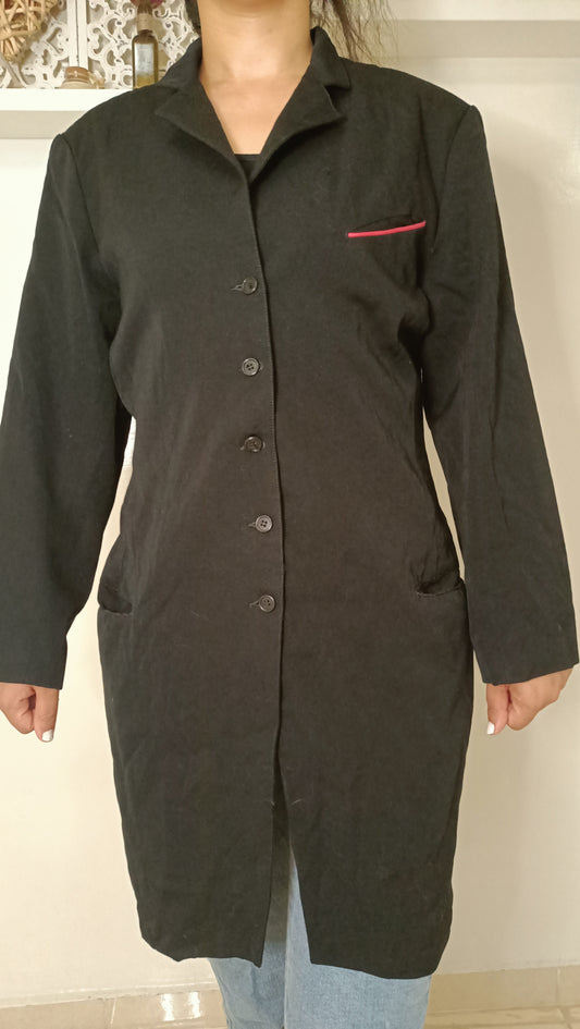 chemise/veste noire, au style épuré et intemporel, est sublimée par son discret passepoil rose sur la poche.