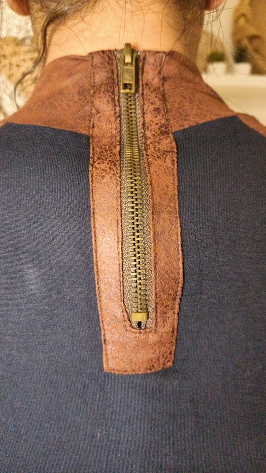 Ce haut bicolore (bleu marine et marron) avec son col montant et ses manches raglan est une pièce au style unique et intemporel. Parfait pour ajouter une touche vintage