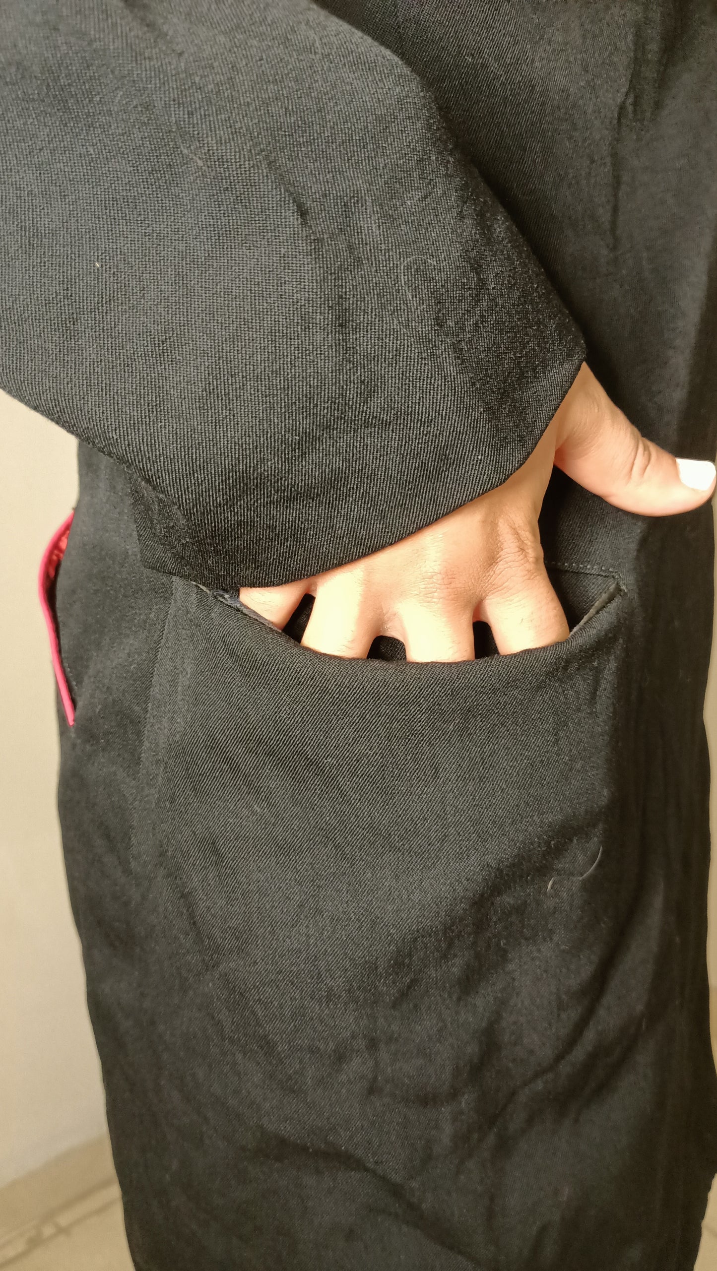 chemise/veste noire, au style épuré et intemporel, est sublimée par son discret passepoil rose sur la poche.