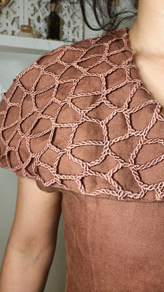 Ce haut vintage marron est une véritable pépite, avec son empiècement travaillé en macramé ou crochet qui lui donne un charme