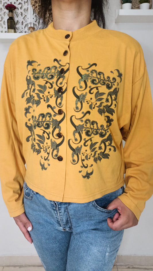 Un rayon de soleil vintage pour ma garde-robe ! ☀️ J'adore ce top moutarde à manches longues, orné de motifs végétaux sombres et complexes qui lui donnent un charme unique.
