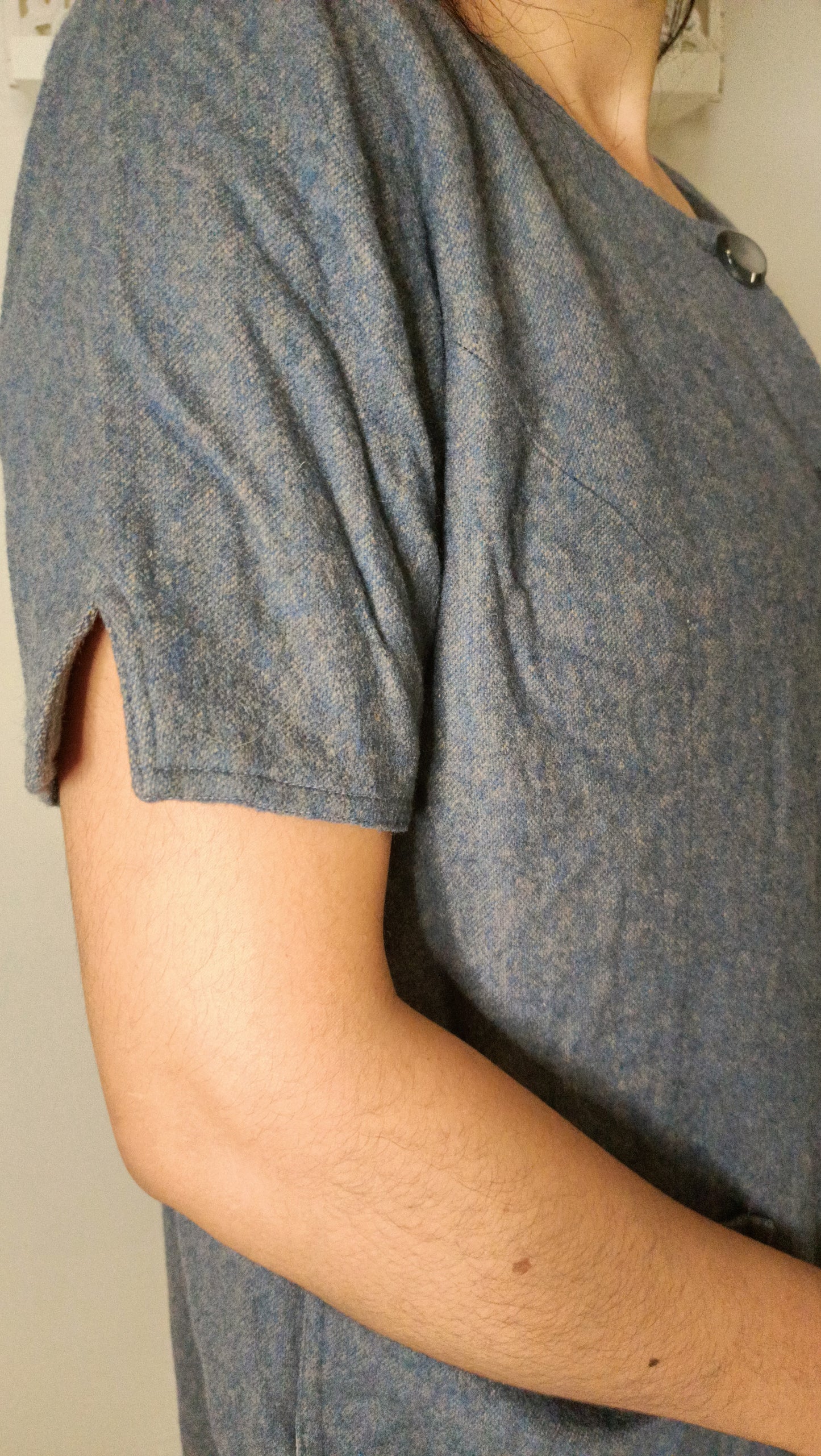 manteau vintage gris chiné a un charme fou avec sa coupe droite, ses manches courtes et ses gros boutons.