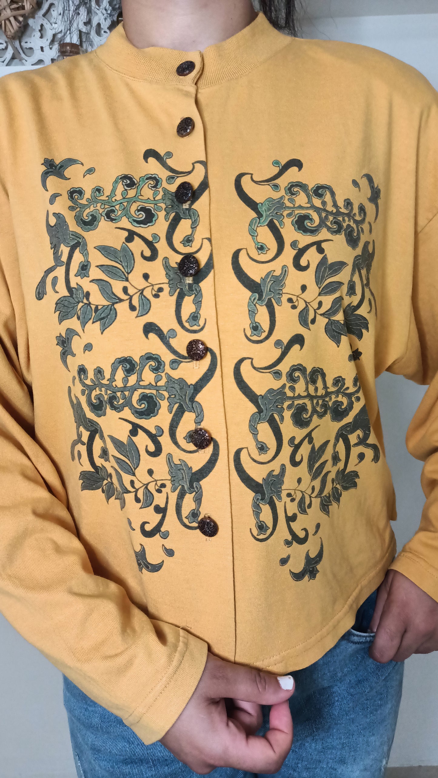 Un rayon de soleil vintage pour ma garde-robe ! ☀️ J'adore ce top moutarde à manches longues, orné de motifs végétaux sombres et complexes qui lui donnent un charme unique.
