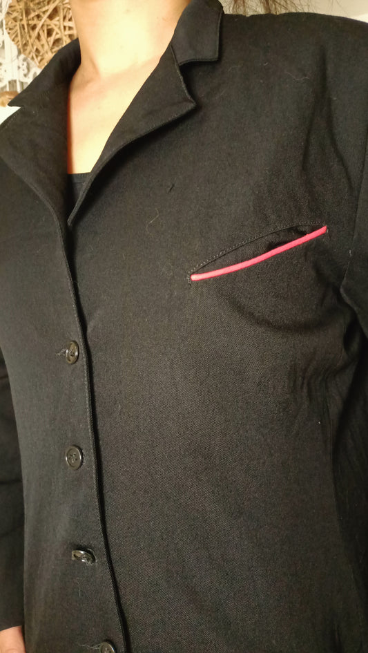 chemise/veste noire, au style épuré et intemporel, est sublimée par son discret passepoil rose sur la poche.